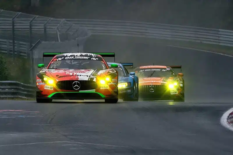 race auto's van mercedes racen over het circuit van de Nurburgring tijdens de dam races. ze rijden door de bocht vlak langs de hekken en de vangrails