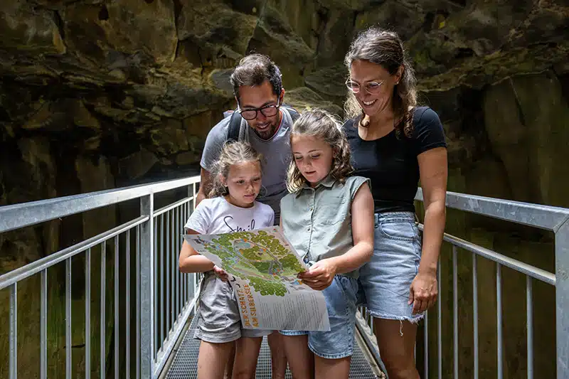 Gezin met kinderen op onderzoek in de steengroeve in Mayen. ze bekijken een kaart