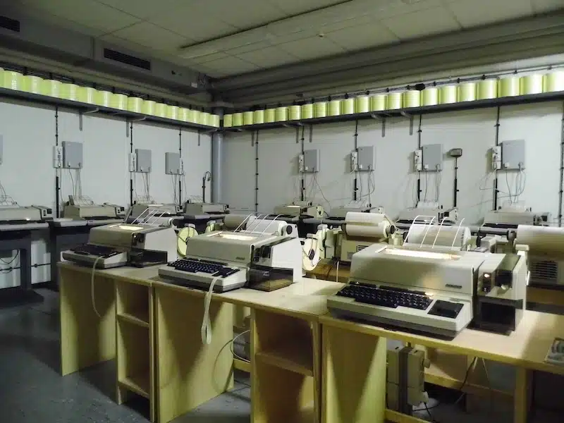 telexruimte bunker. op een rij staan diverse telexapparaten in de ruimte in de bunker
