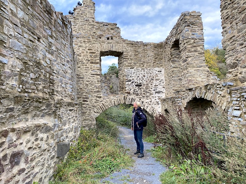 wandelroute Monreal. Het wandelpad loopt door het groen omhoog de heuvel op naar de burcht ruïnes.