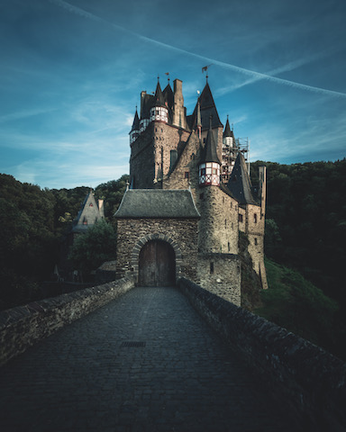 burcht Eltz un het schemer met een donker wordende avondhemel. gefotografeerd vanaf de toegangsweg naar de ingang van de burcht.