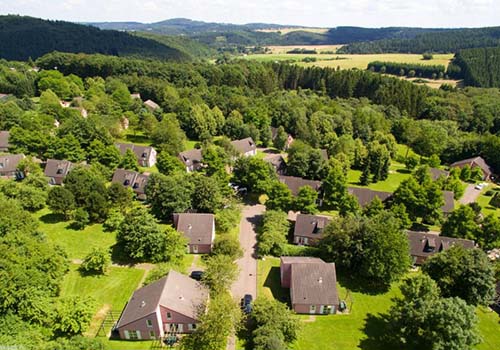 vakantiehuisje op vakantiepark Center Parcs Eifel. van boven gezien de vakantiehuisjes op het park tussen het heuvelachtige groen.