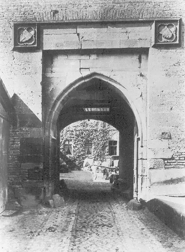 De poort van Burg Zülpich in de late 19e eeuw. een zwartwit foto met de oude poort zoals die vroeger was, de stenen poort met daarachter de burcht